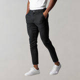 Black chino pants for men, slim fit, cotton, elegant, modern, with white sneakers.