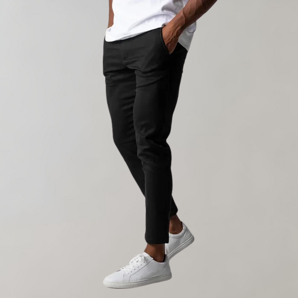 Man wearing black chino pants and white sneakers, casual style, men's fashion.