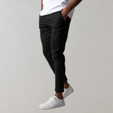 Man wearing black chino pants and white sneakers, casual style, men's fashion.