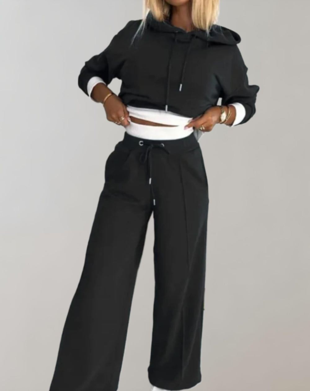 Woman in black hooded jogger set, wide-leg pants, casual fashion, comfortable outfit.