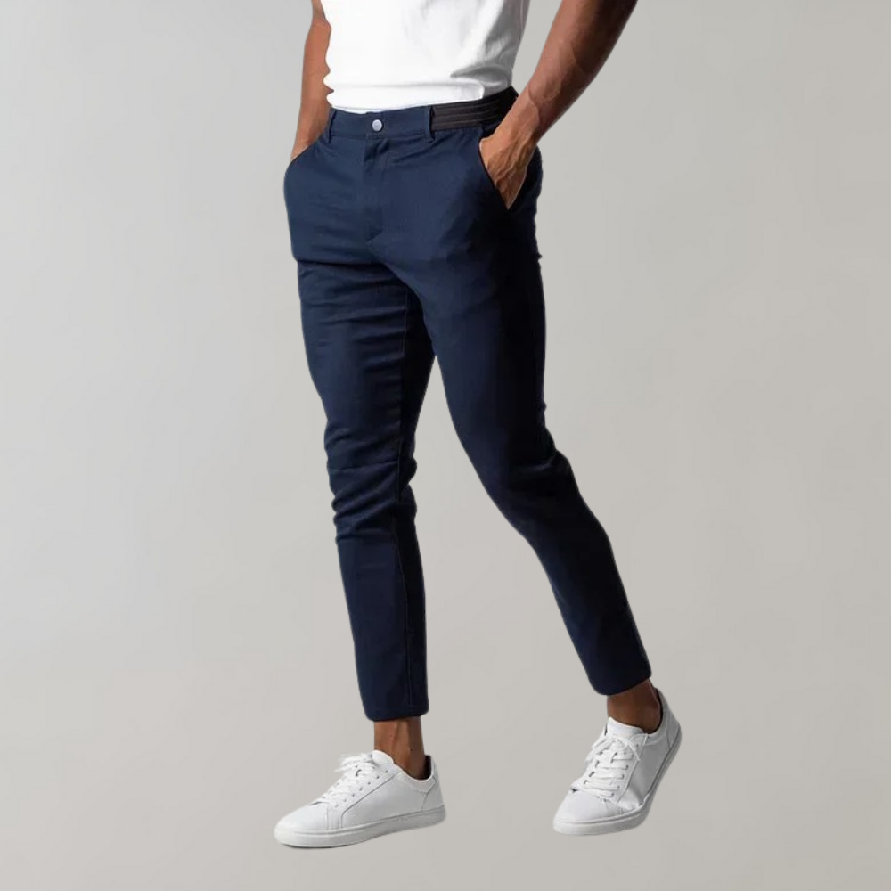 Man wearing dark blue chino pants, white sneakers, casual style, men's fashion.