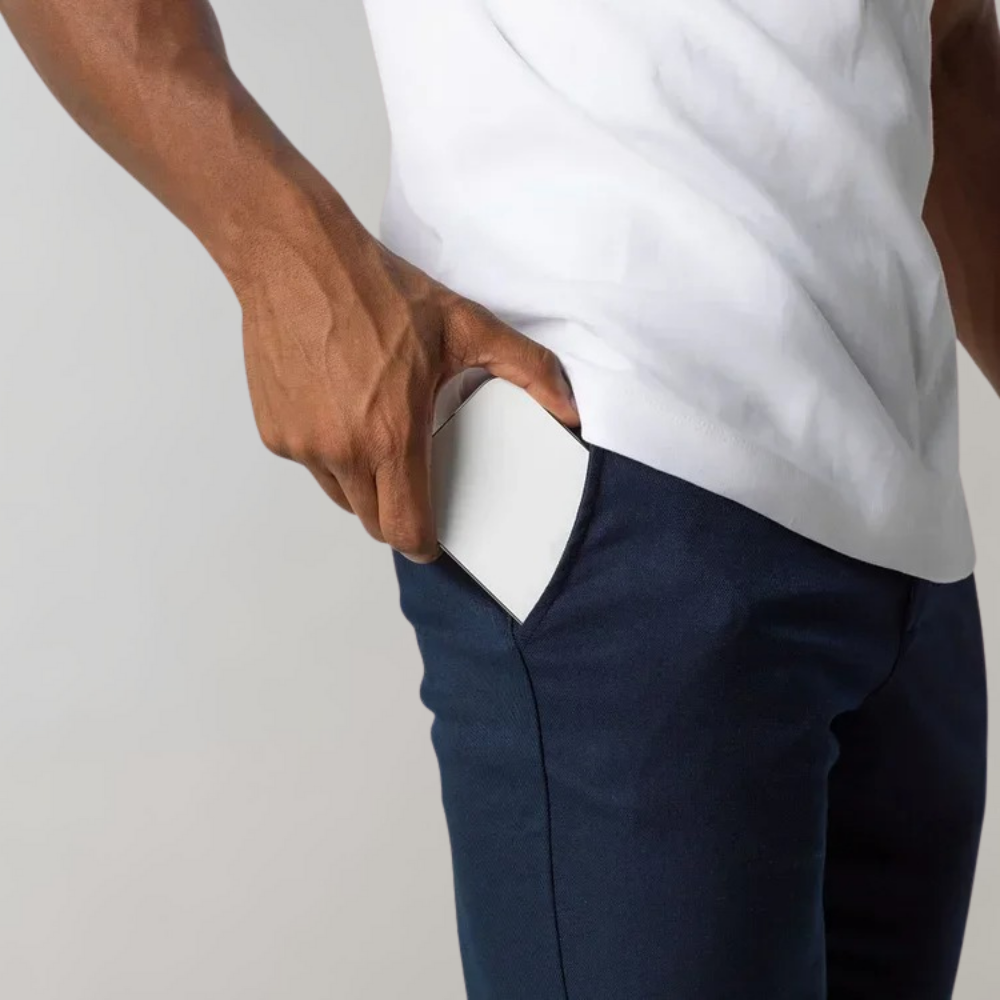 Man putting a white smartphone in a blue pants pocket, technology, mobile device, everyday scene.